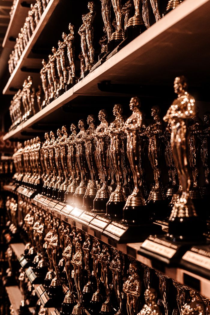 our-journey-01 Close-up image of numerous golden trophy awards neatly arranged on shelves.