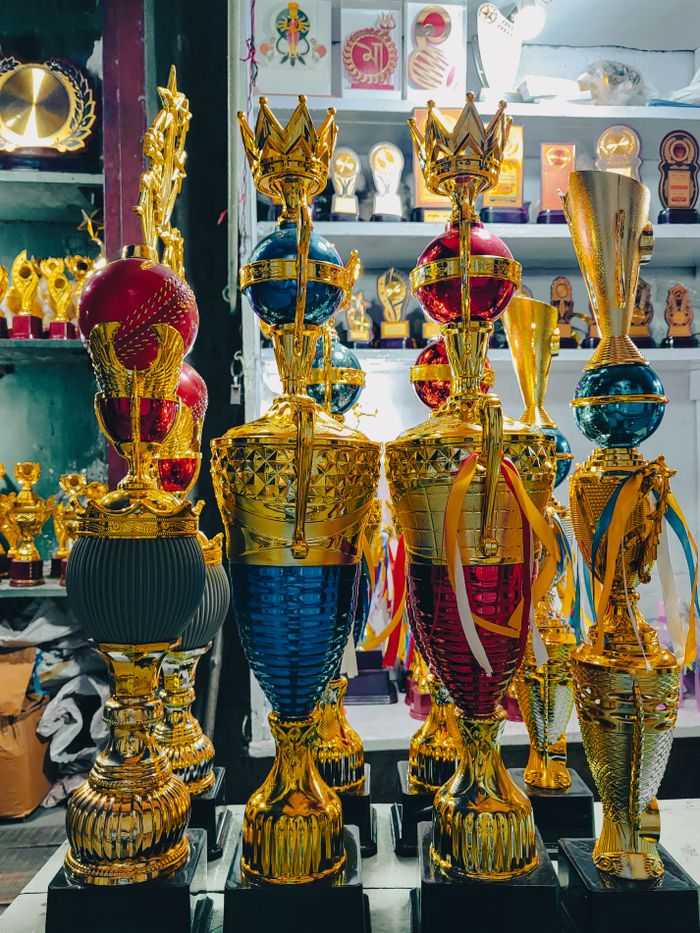 services-01 A vibrant array of golden trophies showcased in a Kolkata awards shop.